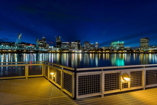 Portland Oregon downtown city skyline from Eastbank Esplanade along Willamette River waterfront during blue hour