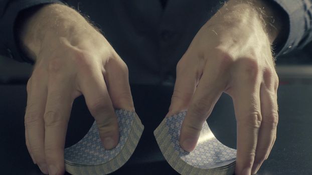 Poker game - shuffling cards. Man's hands shuffing cards. Close up