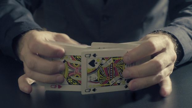 Poker game - shuffling cards. Man's hands shuffing cards. Close up