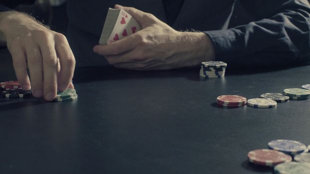 Poker game - dealing cards. Man's hands dealing cards and chips. Close up