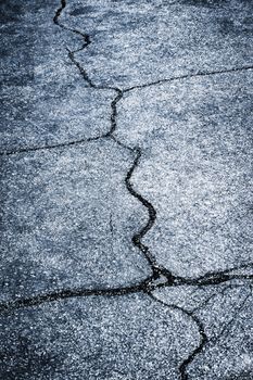 abstract background or texture wide cracks on a dark asphalt