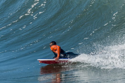 Bodyboarder in action on the ocean waves on a sunny day.