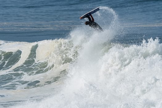 Bodyboarder in action on the ocean waves on a sunny day.