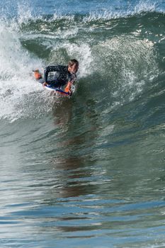 Bodyboarder in action on the ocean waves on a sunny day.