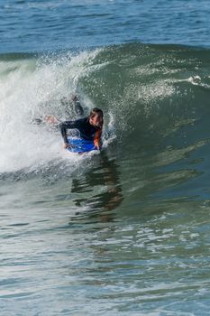 Bodyboarder in action on the ocean waves on a sunny day.