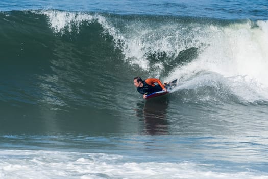 Bodyboarder in action on the ocean waves on a sunny day.