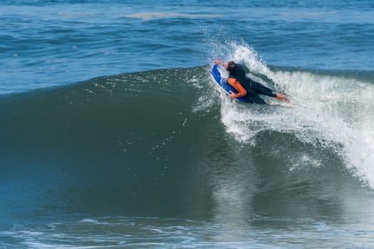 Bodyboarder in action on the ocean waves on a sunny day.