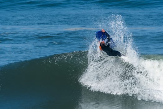 Bodyboarder in action on the ocean waves on a sunny day.