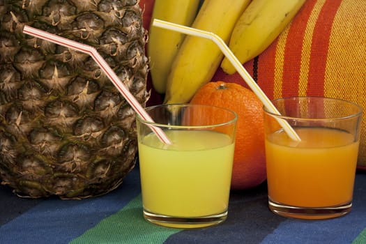 Glasses with anansovym and orange juice and straws still life 