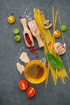 Italian food concept. Spaghetti with ingredients sweet basil ,tomato ,garlic peppercorn ,champignon,zucchini and parmesan cheese on dark background flat lay and copy space.