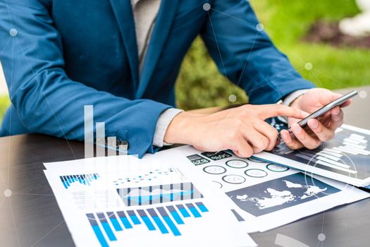 Handsome businessman wearing suit and using modern laptop outdoors and graph finance diagram.