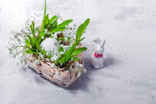 Bunny, eggs and white flowers. Easter symbols