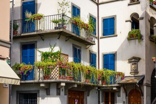 Colorful and ancient house with many flowers and plant at the balcony,in the historic centre of the Pisogne town.