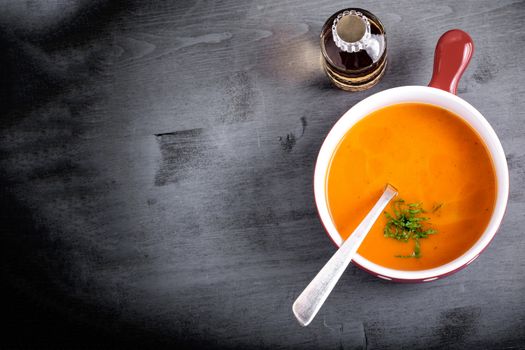 Pumpkin creme soup with a spoon served on a table