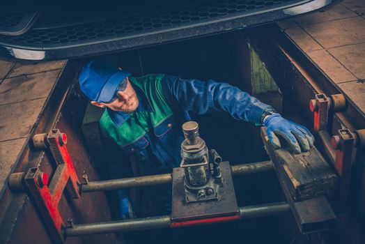 Car Mechanic Working Under the Car To Fix Vehicle Exhaust System. Car Maintenance.