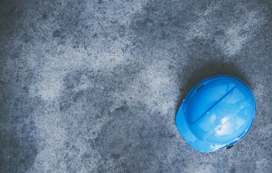 Construction Helmet Hard Hat on the Raw Concrete Floor. Construction Safety Concept Photo with Copy Space. Home Improvement Theme.