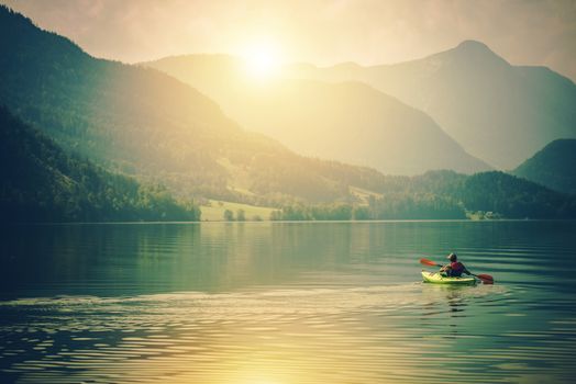 Lake Kayak Touring. Summer Recreations and Sport Photo Concept. Senior Sportsman in the Tour Kayak on the Lake.