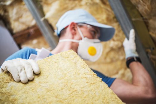 Mineral Rock Wool Insulating Concept Photo. Worker with Piece of Insulating Wool in Hands.