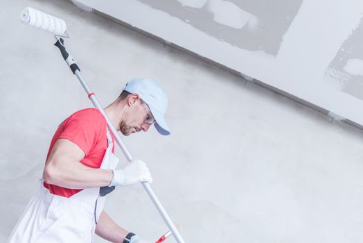 Room Painter Work to Do. Caucasian Painter in His 30s with Painting Roller Preparing For His Job.