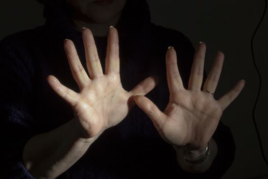 Female hands with ten fingers in the dark
