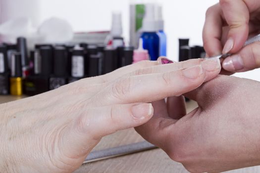 Professional manicure procedure in beauty salon. Hands close up.