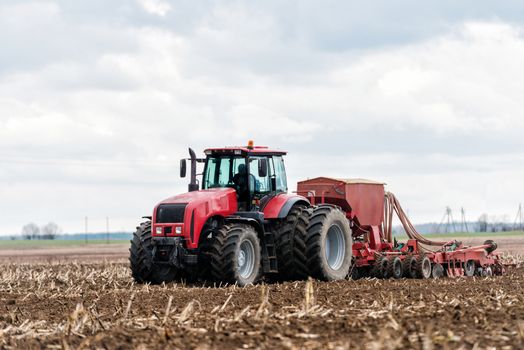 Farmer tractor working in the field. Spring time for sowing. Planting crops. 