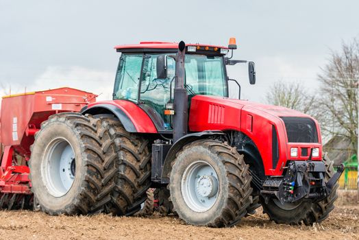 Farmer tractor working in the field. Spring time for sowing. Planting crops. 