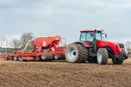 Farmer tractor working in the field. Spring time for sowing. Planting crops. 