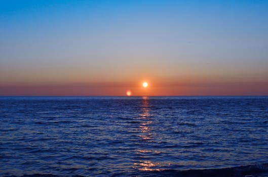 Bright orange sunset over the dark blue sea