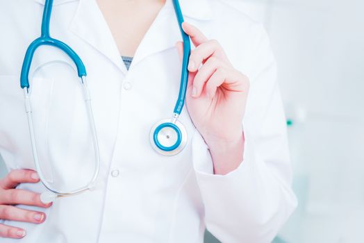 Female Doctor with Stethoscope Closeup Photo. Hand on the Stethoscope. Doctor Office Concept.