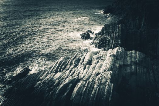 Rocky Mediterranean Sea Shore in the Italian Liguria Region near La Spezia. Mediterranean Landscape and Geology. Dark Bluish Color Grading.
