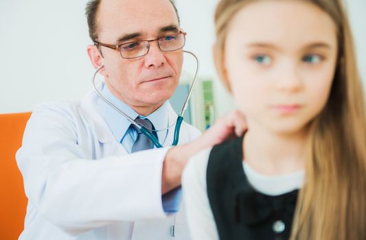 Pediatric Senior Doctor Examining Little Girl Using Stethoscope