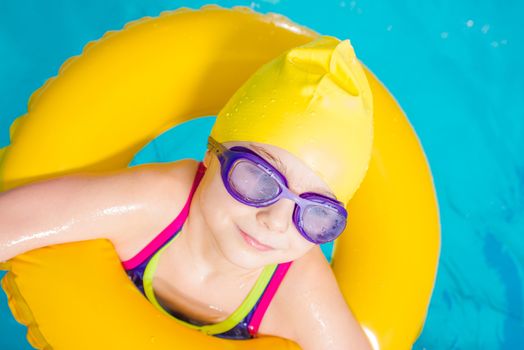 Little Caucasian Girl Learn to Swim in the Swimming Pool. Closeup Photo