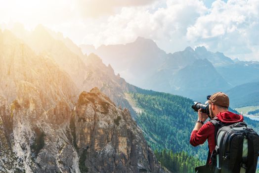 Caucasian Photographer in His 30s and the Wilderness. Photo Session in the Italian Alps. Taking Scenic Pictures.