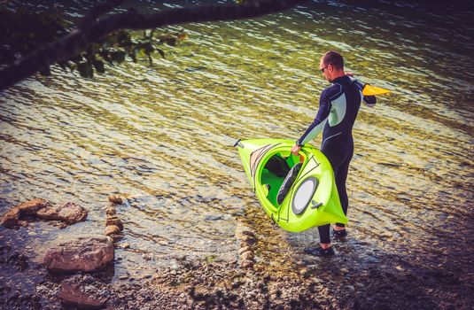 Caucasian Sportsman Preparing For Exciting Kayak Trip on the Scenic Lake.