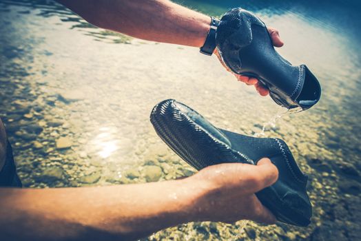 Cleaning Wet Shoes After Kayaking. Closeup Photo. Water Sports Accessories.