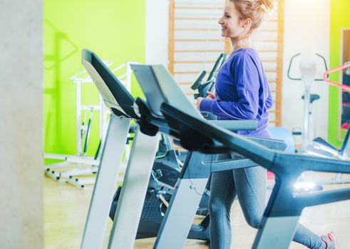 Woman on Fitness Treadmill. Caucasian Woman Workout in the Fitness Center.