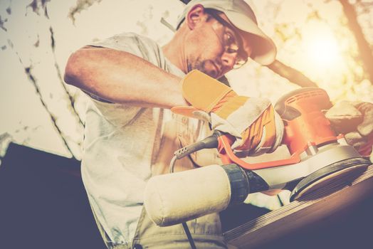 Worker Wood Sanding. Caucasian Men with Wood Sender Machine Sanding Wood Furniture Outdoor.