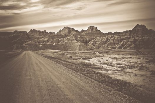 Raw Badlands Landscape in Sepia Color Grading. South Dakota Nature Landscape and the Rural Road.