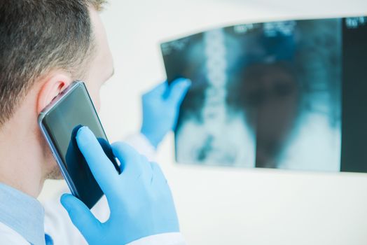 Medical Doctor Consulting Xray Imagery Results by Phone. Healthcare Photo Concept.