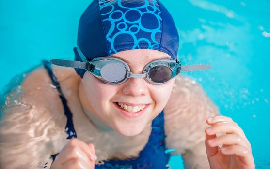 Girl in the Swimming Pool Learning How to Swim. Girl with Water Goggles Portrait.