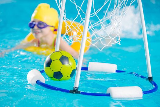 Swimming Pool Games. Children Playing with Ball in the Pool.