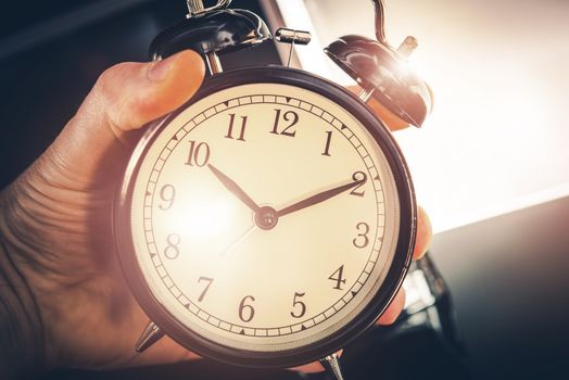 Time is Running Out. Large Classic Alarm Clock in a Hand.