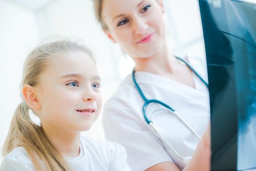 Medical Practitioner Explaining X Ray Imagery to Little Girl in the Xray Imaging Hospital Room.