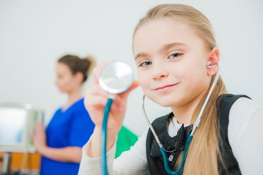 Caucasian Girl Playing Doctor Using Stethoscope in the Doctor Office.