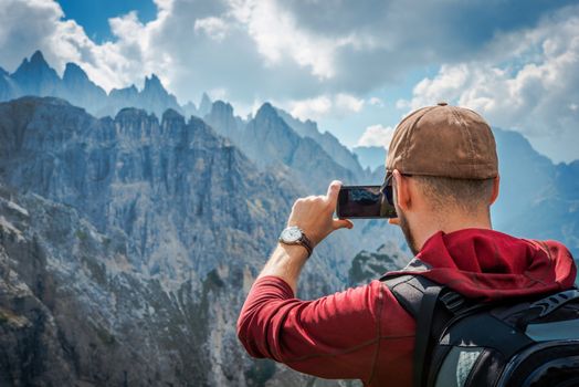 Hiking Tourist Taking Photos Using His Hi-End Smartphone Device. Travel Concept. Mountain Hiker.