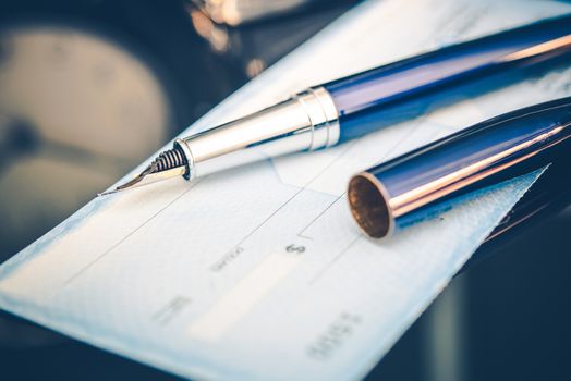 Issuing Payment by Check by Using Elegant Fountain Pen. Executive Desk Closeup.