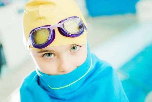 Swimming Pool Fun Time. Caucasian Girl Covered By Pool Blue Towel. Closeup Photo. Girl Wearing Water Goggles