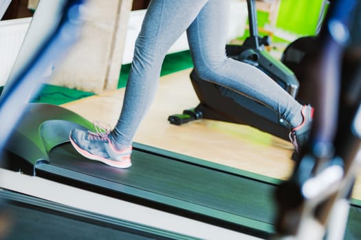 Treadmill Fitness Running Closeup Photo. Female Running on the Treadmill in the Fitness Center.