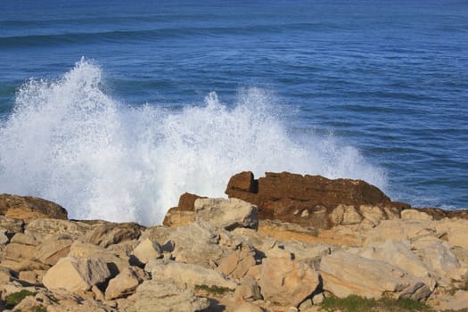 Marine wave breaks against offshore stone